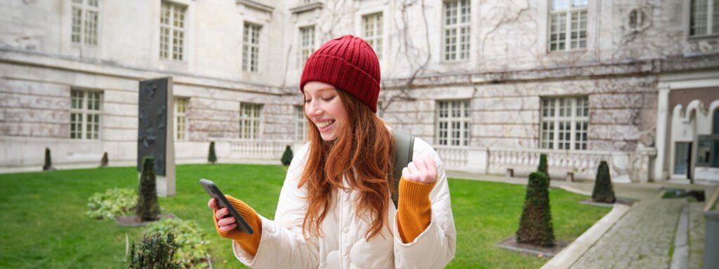 The current image has no alternative text. The file name is: portrait-cheerful-redhead-woman-with-smartphone-celebrating-reading-amazing-news-rejoicing-scaled.jpg